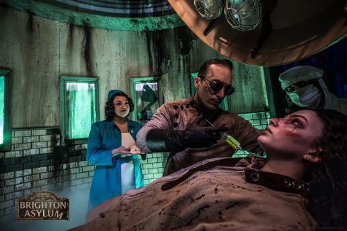 Actors perform a medical-themed scene inside Brighton Asylum, an immersive haunted attraction.